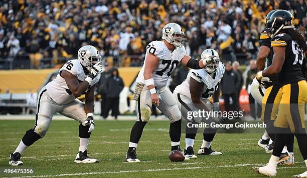 Center Tony Bergstrom of the Oakland Raiders signals at the line of scrimmage as guards J'Marcus Webb and Gabe Jackson look on during a game against...