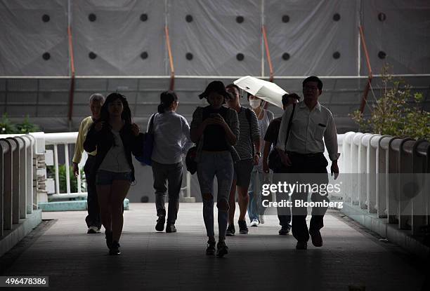 Pedestrians walk on an overpass in Taipei, Taiwan, on Monday, Nov. 9, 2015. In his meeting Saturday with outgoing Taiwanese President Ma Ying-jeou,...