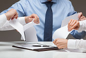 Business people cruelly tearing documents