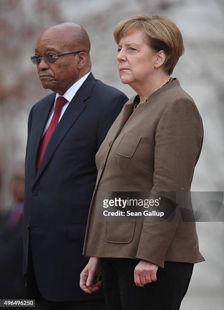 German Chancellor Angela Merkel and South African President Jacob Zuma listen to their countries' national anthems upon Zuma's arrival at the...