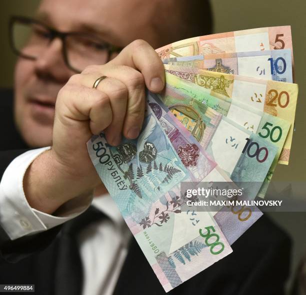 An official of Belarus' National Bank shows the new Belarus' ruble banknotes during a presentation in Minsk on November 10, 2015. Belarus will slash...