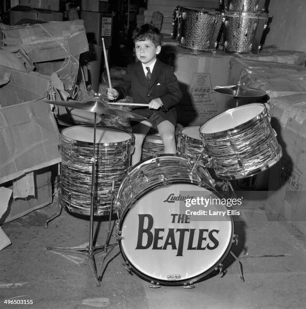 Johnny Arbiter, the son of an importer, playing a miniature set of 'The Beatles' drums, imported by Ringo Starr from Chicago, May 28th 1964.