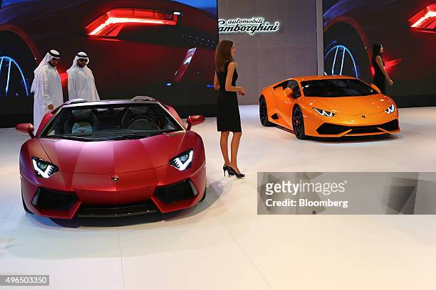 Visitors inspect a Lambourghini Aventador LP700-4 automobile on the Automobili Lamborghini SpA stand during the Dubai Motor Show at the World Trade...