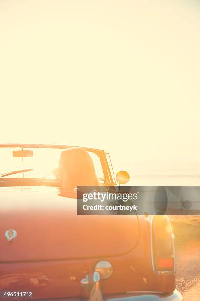 donna guida un'auto cabrio in spiaggia. - old fashioned australian beach foto e immagini stock