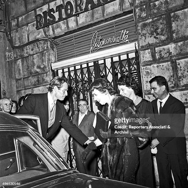 American actor Charlton Heston, in Rome to shoot the film 'Ben Hur', leaving teatro Sistina and helping his mother Lila Charlton to get on board the...