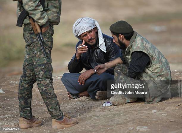 Kurdish soldiers from the Syrian Democratic Forces take a break from frontline action at a forward operating base on November 10, 2015 near the...