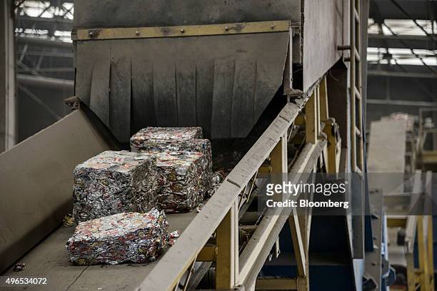 Bales of crushed aluminium cans move down a conveyer belt toward an oven for melting at the at the Latasa Reciclagem SA collection center in...