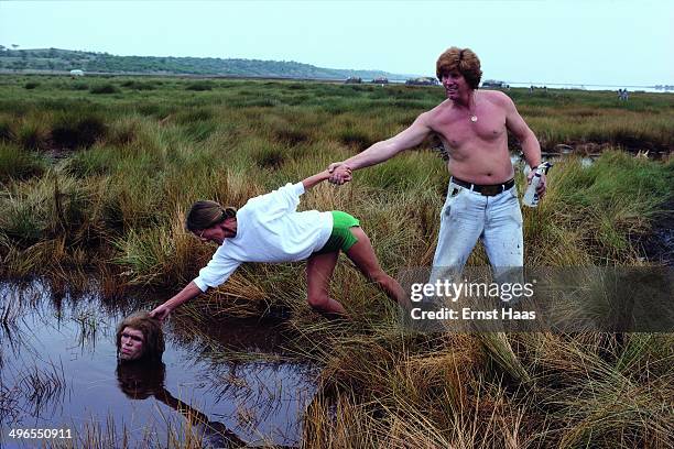 American actor Everett McGill up to his neck in a pond whilst filming the quicksand scene for 'Quest for Fire', 1980.