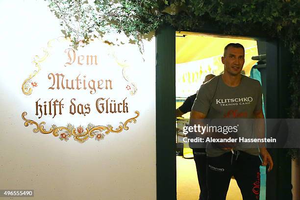 Wladimir Klitschko passes a slogan written on a wall, translated as "the braveheart helps the good luck", as he arrives for a training session at...