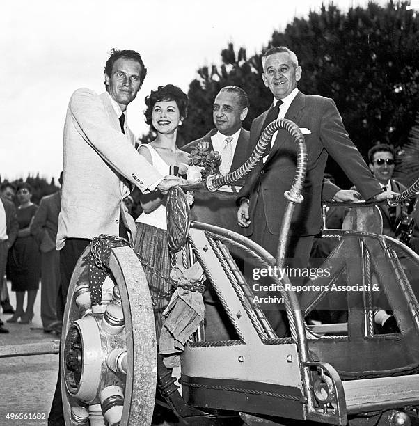 American actor Charlton Heston posing on a chariot with his wife and American actress Lydia Clarke, American producer Sam Zimbalist and American...