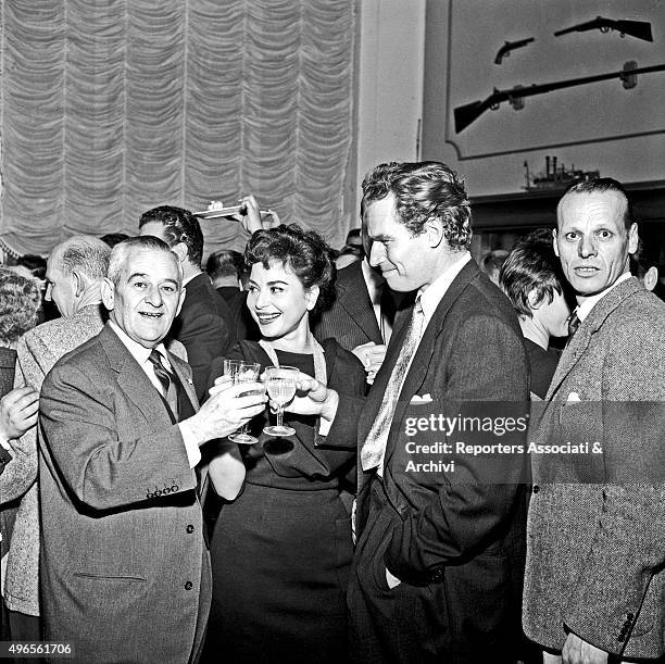 American actor Charlton Heston having a toast with American director William Wyler and Israeli actress Haya Harareet at the restaurant 'Vecchia...