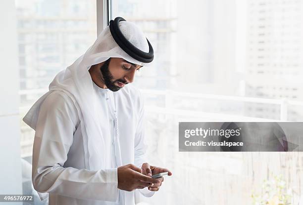 solitary arab man on phone inside city flat - middle eastern male on phone isolated stock pictures, royalty-free photos & images