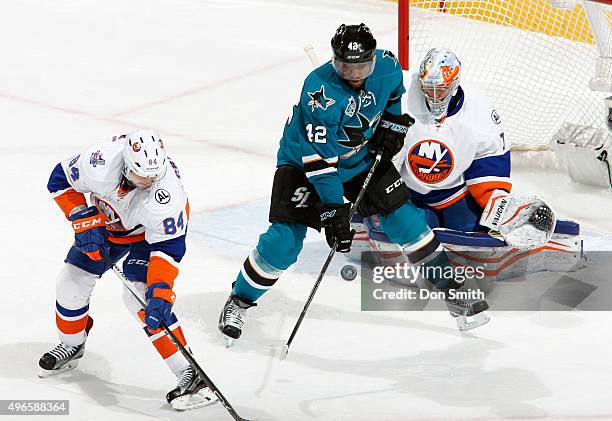 Joel Ward of the San Jose Sharks gets a stick on the puck against Mikhail Grabovski and Thomas Greiss of the New York Islanders during a NHL game at...