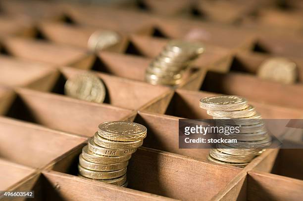stack of british pound coins in a wooden box - bringing home the bacon engelse uitdrukking stockfoto's en -beelden