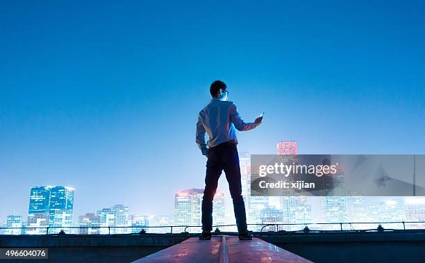 businessman using smart phone - beijing skyline night stock pictures, royalty-free photos & images