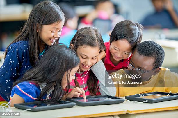 kinder spielen auf einem tablet-computer - classroom play stock-fotos und bilder