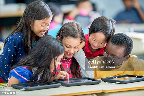 children playing games on a tablet - watching ipad stock pictures, royalty-free photos & images