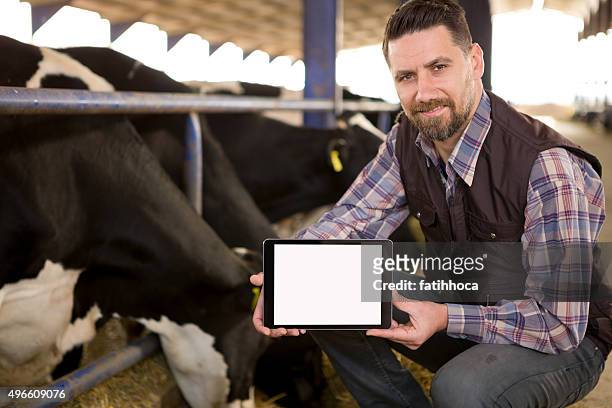 joven agricultor y tableta digital - livestock show fotografías e imágenes de stock