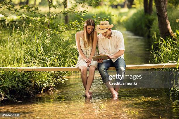 junges paar mit digitalen tablet - couple jeans shirt stock-fotos und bilder