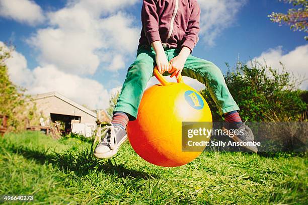 child playing on a space hopper - bouncing stockfoto's en -beelden