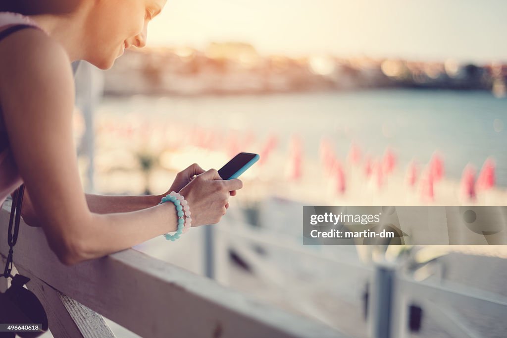 Girl at a veranda text messaging on the phone