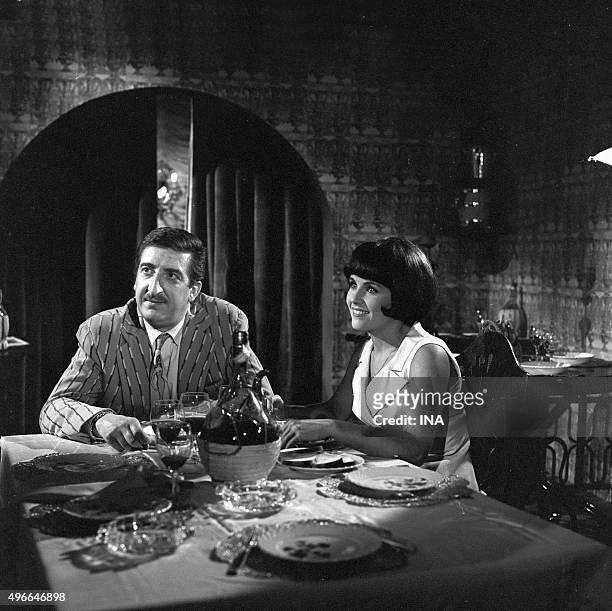 Sat at the table in a restaurant, Marie-France BOYER and Pierre TORNADE in a scene of the serial "How do not marry a billionaire".