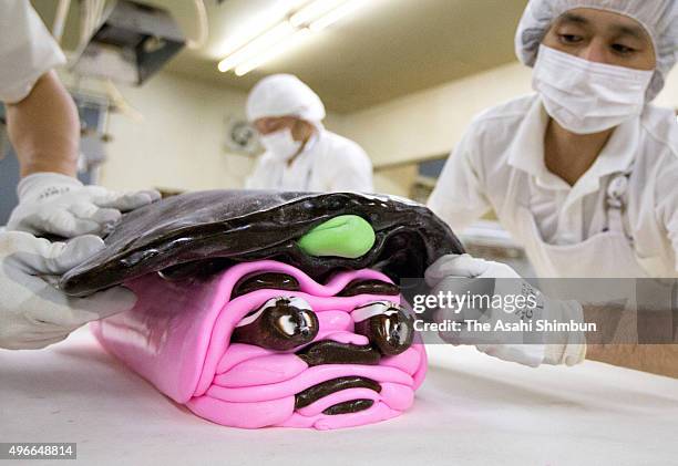 Confectioners at Kintaro Ame Honten assemble the facial parts of "Kiintaro" for "Chitose Ame" candy ahead of the "Shichi-Go-San" festival for...