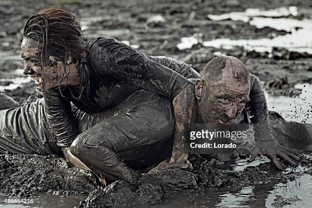 man and woman mud wrestling - rough housing stockfoto's en -beelden