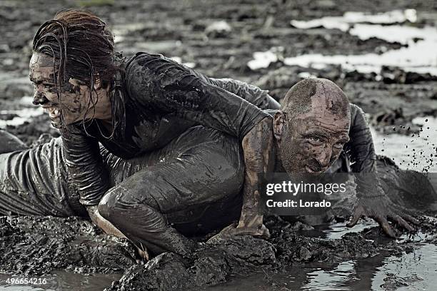 man and woman mud wrestling - mud wrestling stock pictures, royalty-free photos & images