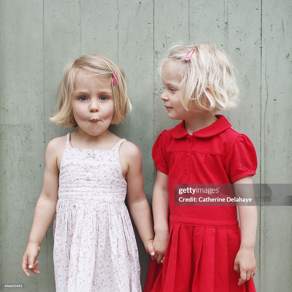 Two 3 years old twins girls posing together