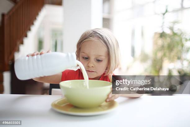 a 3 years old girl taking her breakfast - milk bottle photos et images de collection