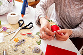 Senior women sews by hand