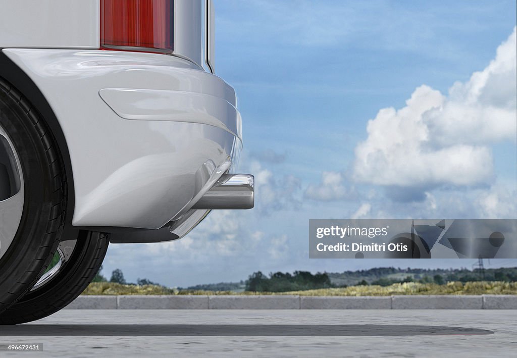 Rear of car, exhaust pipe in front of cloudy sky