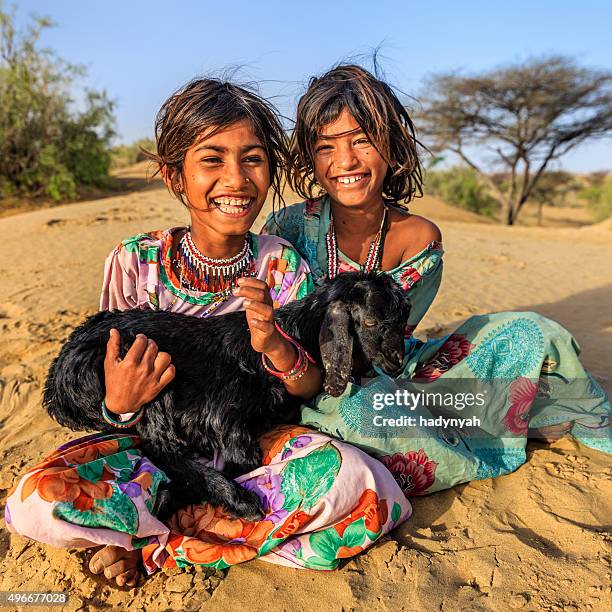 glücklich indischen mädchen holding eine ziege, desert village, india - rajasthani youth stock-fotos und bilder