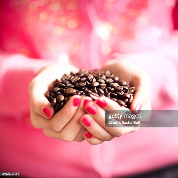 girl holding coffee beans in hands - coffee beans scoop stock pictures, royalty-free photos & images