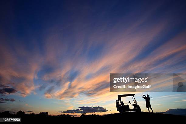 unrecognizable male golfer swinging by his golf cart with sky - golf swing from behind stock pictures, royalty-free photos & images