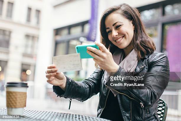 new york woman depositing check remotely - portable information device stock pictures, royalty-free photos & images
