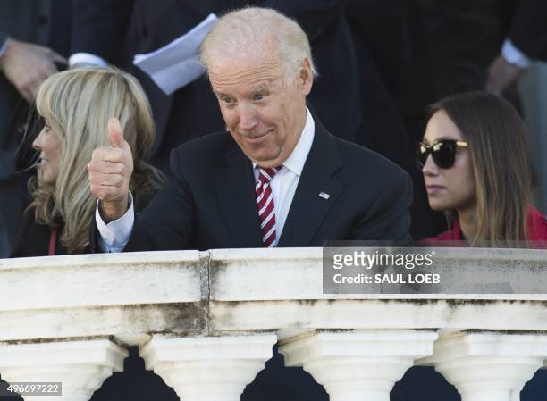 Vice President Joe Biden gives a thumbs-up as he arrives for a Veteran's Day ceremony at Arlington National Cemetery in Arlington, Virginia, November...