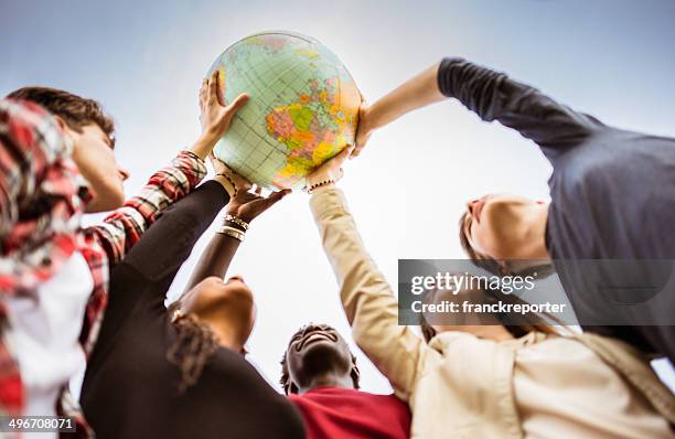 teenagers reaching the world at campus - globe navigational equipment stockfoto's en -beelden