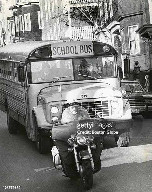 Police officer leads a decoy school bus down G Street in South Boston, Mass. On Dec. 11, 1974 as a crowd rioted outside South Boston High School...