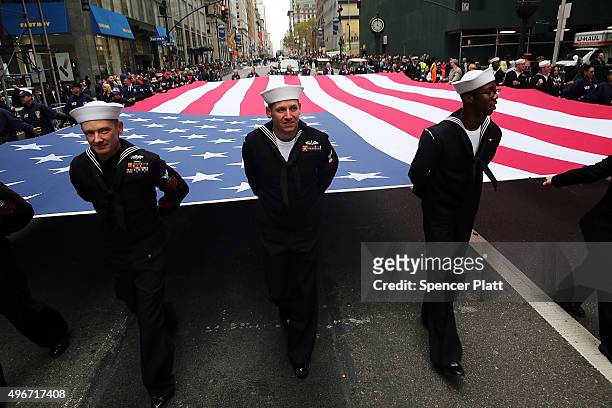 Members of the U.S. Navy march with the American Flag in the the nation's largest Veterans Day Parade in New York City on November 11, 2015 in New...