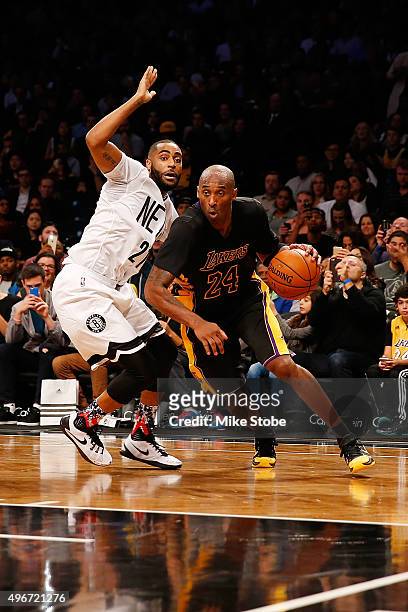 Kobe Bryant of the Los Angeles Lakers drives to the net for a basket against Wayne Ellington of the Brooklyn Nets at the Barclays Center on November...