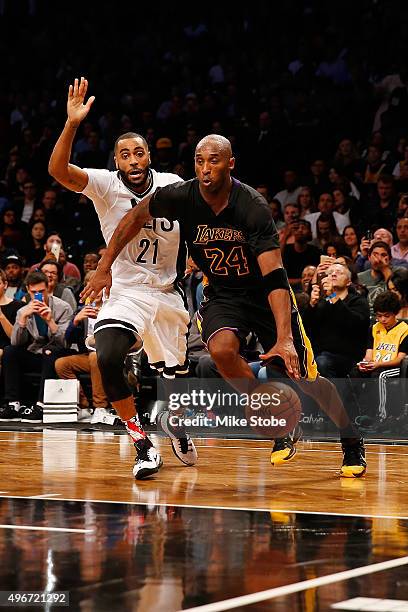 Kobe Bryant of the Los Angeles Lakers drives to the net for a basket against Wayne Ellington of the Brooklyn Nets at the Barclays Center on November...