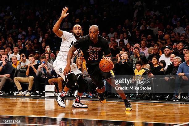 Kobe Bryant of the Los Angeles Lakers drives to the net for a basket against Wayne Ellington of the Brooklyn Nets at the Barclays Center on November...