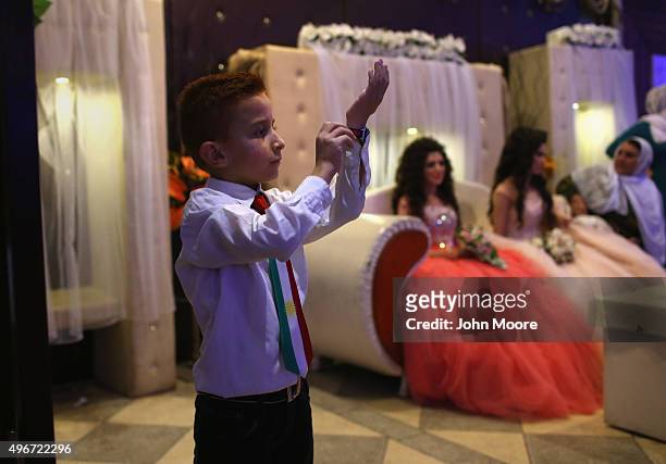 Boy watches as guests dance during a wedding reception on November 11, 2015 near Qamishli, in the autonomous Kurdish region of Rojava, Syria. Two...