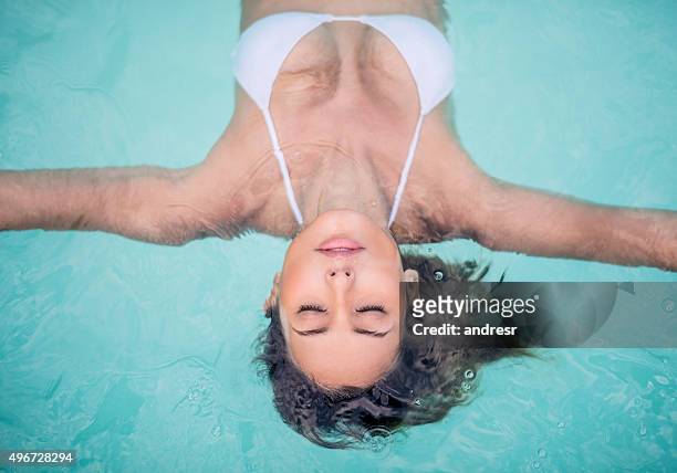 beautiful woman in the swimming pool at the spa - drijven stockfoto's en -beelden