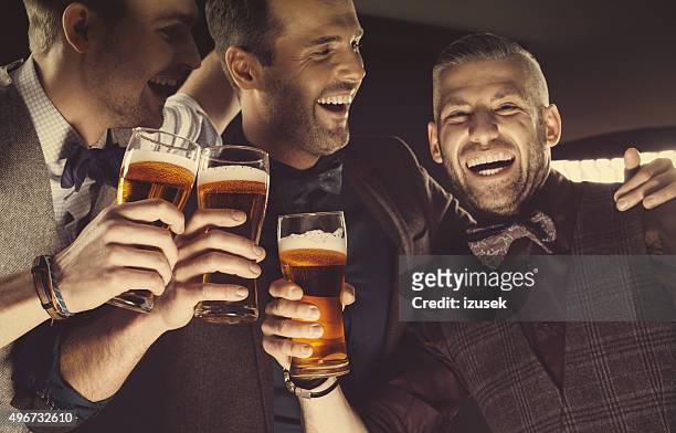 happy elegant men toasting with beer - beer luxury stock pictures, royalty-free photos & images