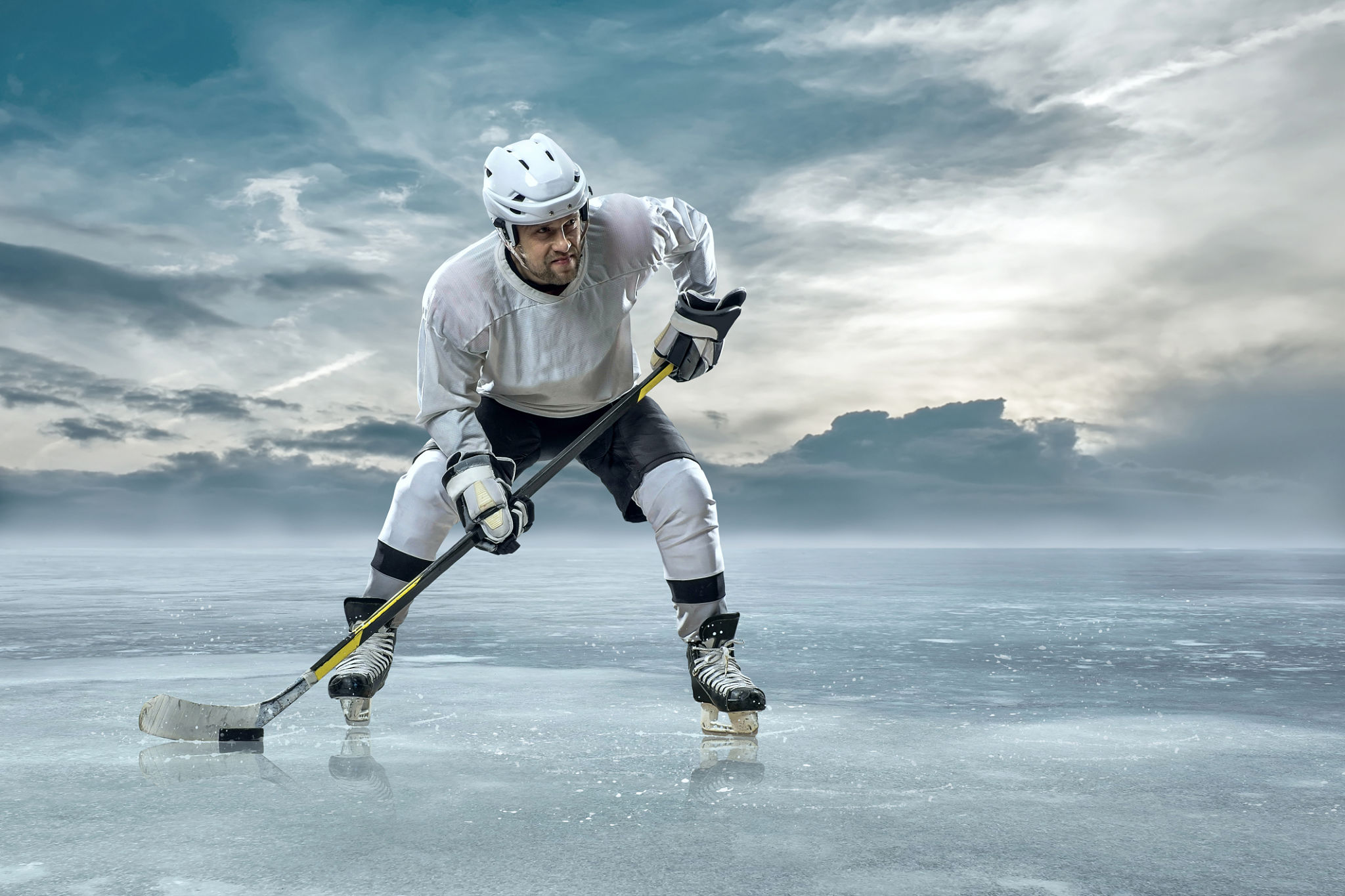 Ice hockey player on the ice in mountains Ice hockey player on the ice in mountains