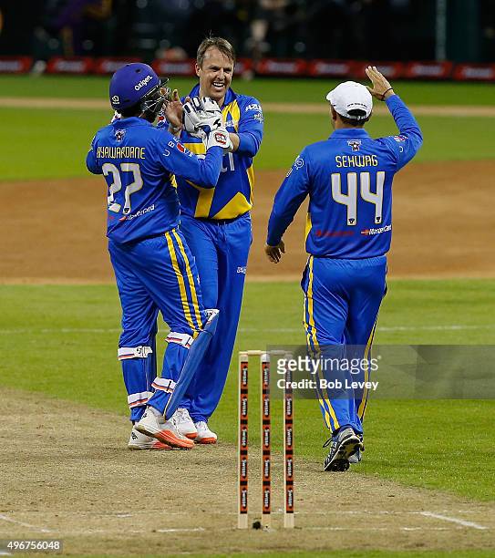 Graeme Swann, center, congratulates Mahela Jayawardene, left and Virender Sehwag after getting the side out during the Cricket All-Stars Series at...