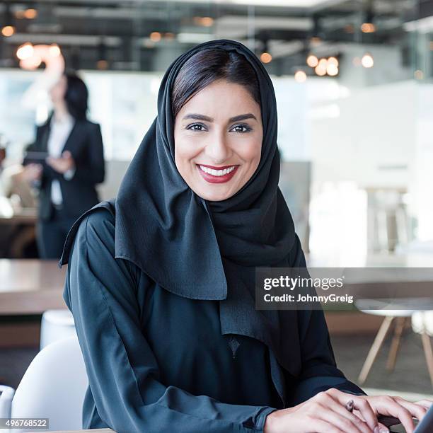 attractive arab businesswoman wearing hijab smiling towards camera - emarati woman stock pictures, royalty-free photos & images